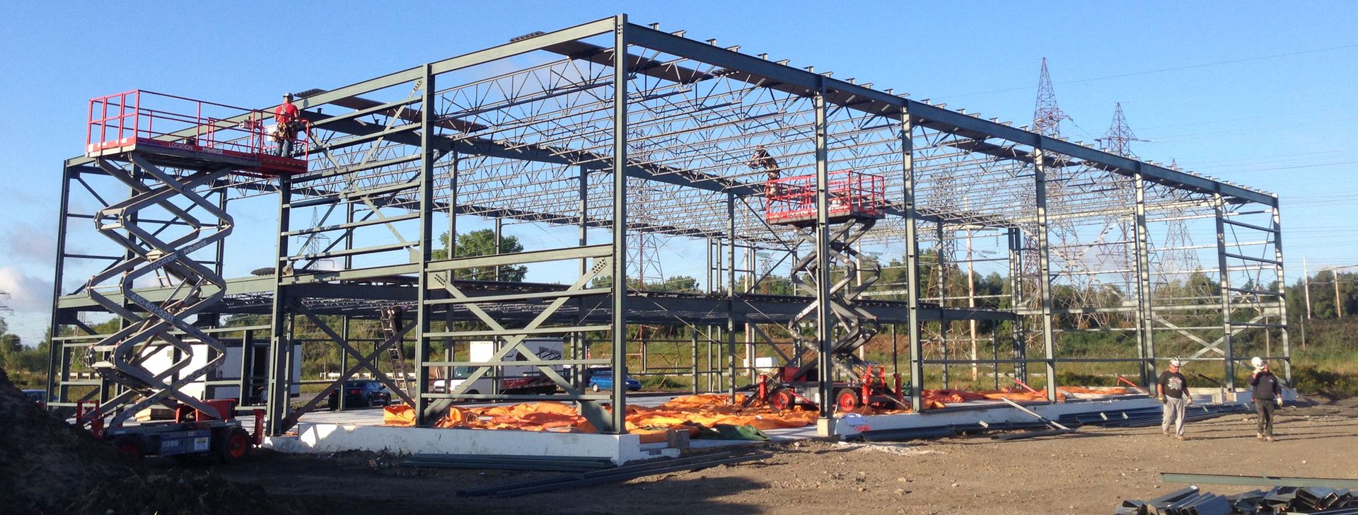 The steel frame of a commercial building being erected, with a crane in the background.