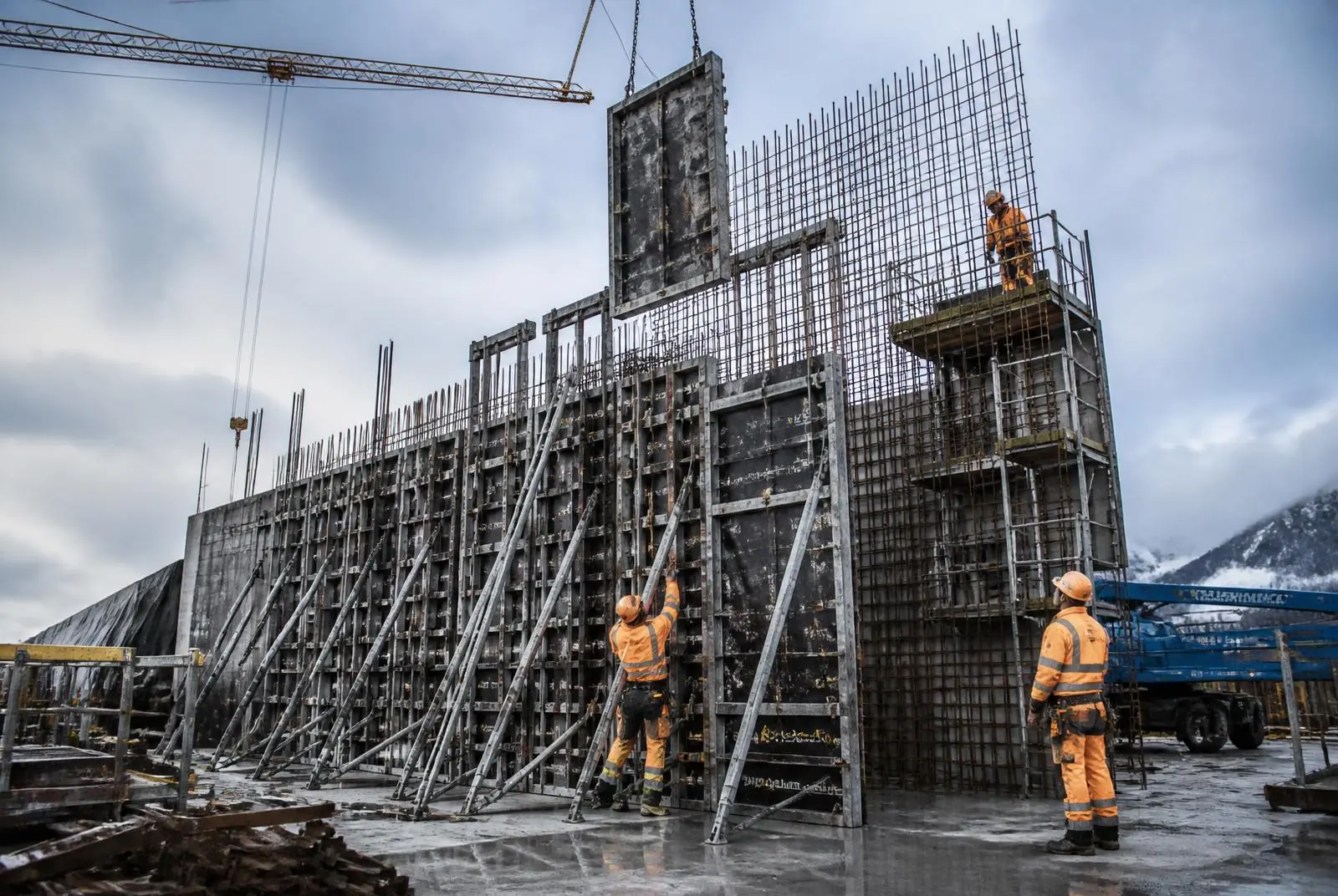 Charpentiers assemblant un coffrage de bois avant une coulée de béton.